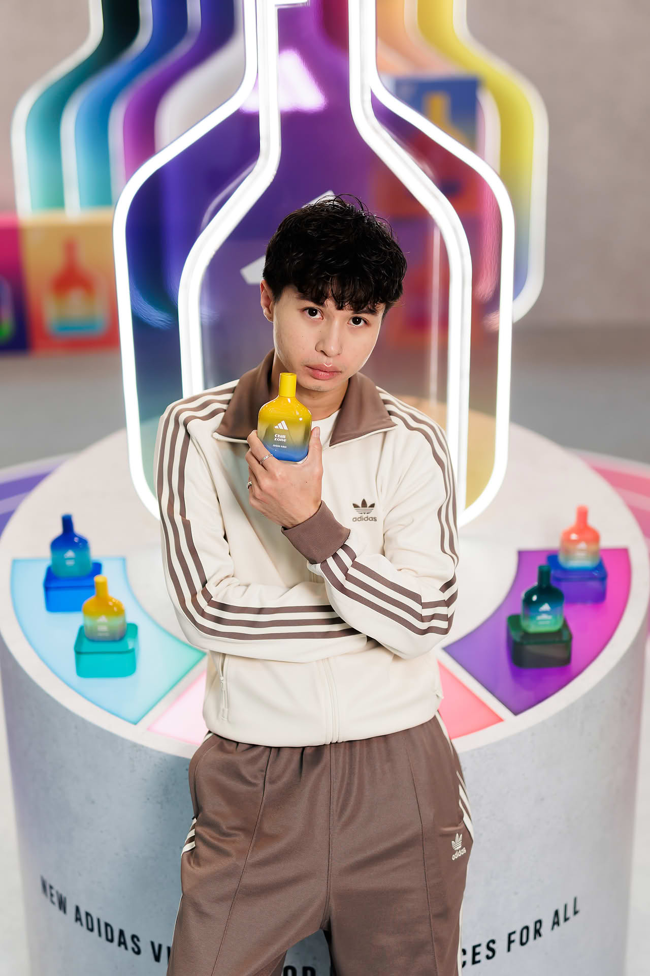 Influencer posing with perfume at Addidas Vibe pop-up stall in Plaza Singapura
