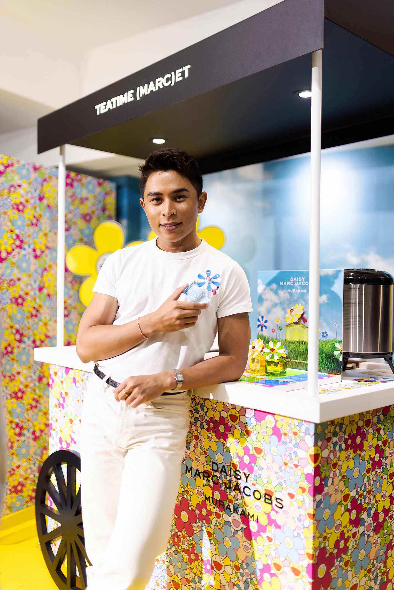 Influncer posing with perfume at Marc Jacobs pop-up stall