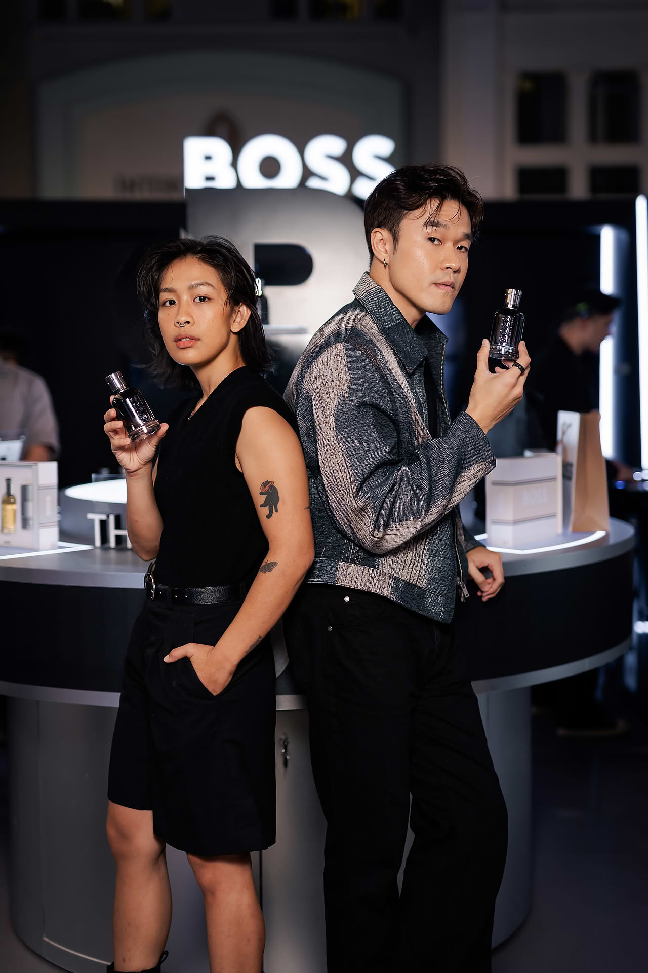 Influencers posing with perfume at BOSS pop-up stall in Bugis Junction
