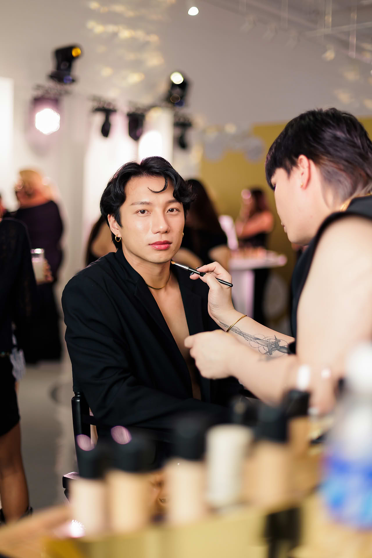 Influencer having his makeup done by a makeup artist at MAC Cosmestics PR event