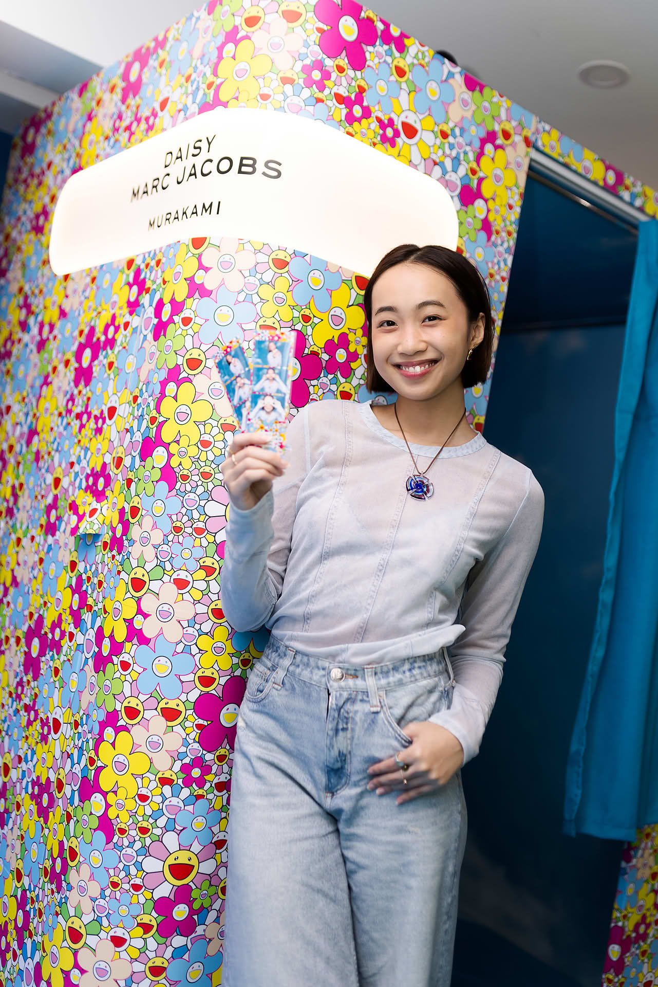 Actress showing her photos taken at the photo booth at Marc Jacobs pop-up stall