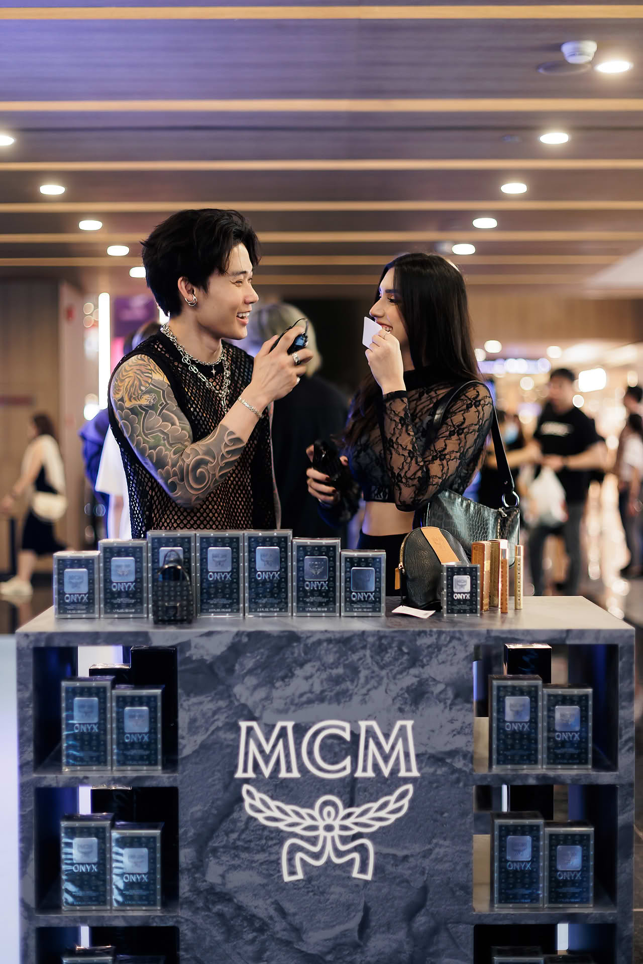 Influencers testing perfume at MCM pop-up stall at Paragon