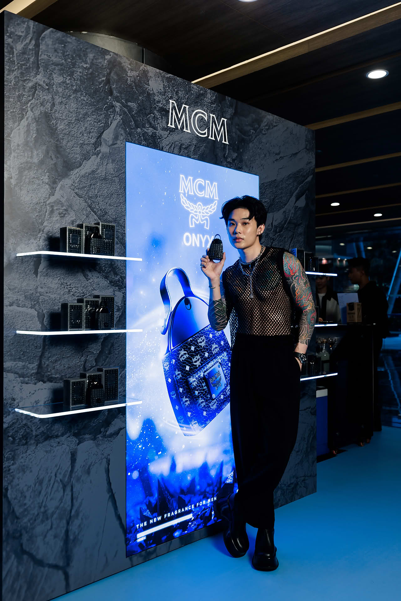 Influencer posing with perfume at MCM pop-up stall at Paragon
