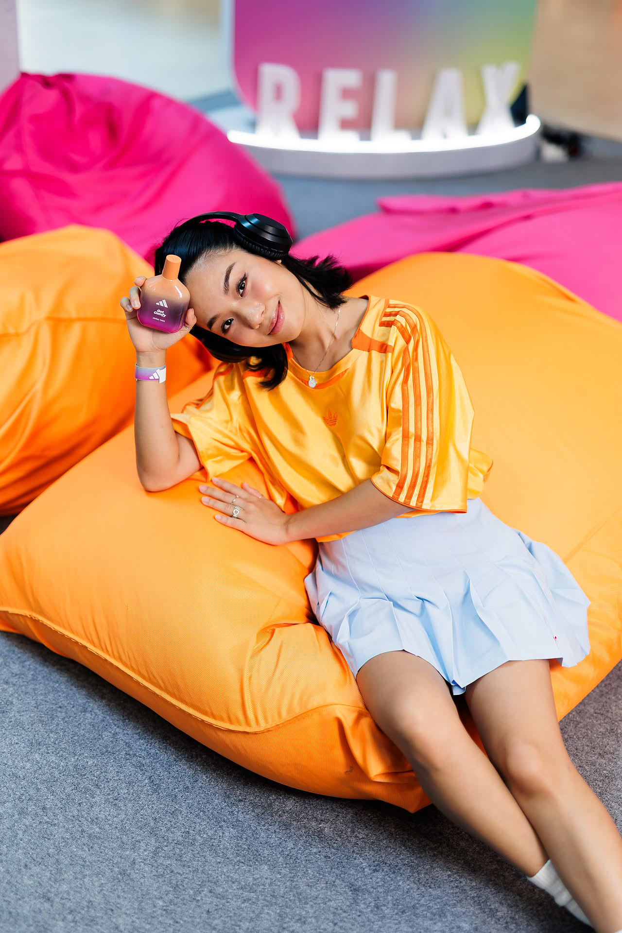 Influencer posing with perfume at Addidas Vibe pop-up stall in Plaza Singapura
