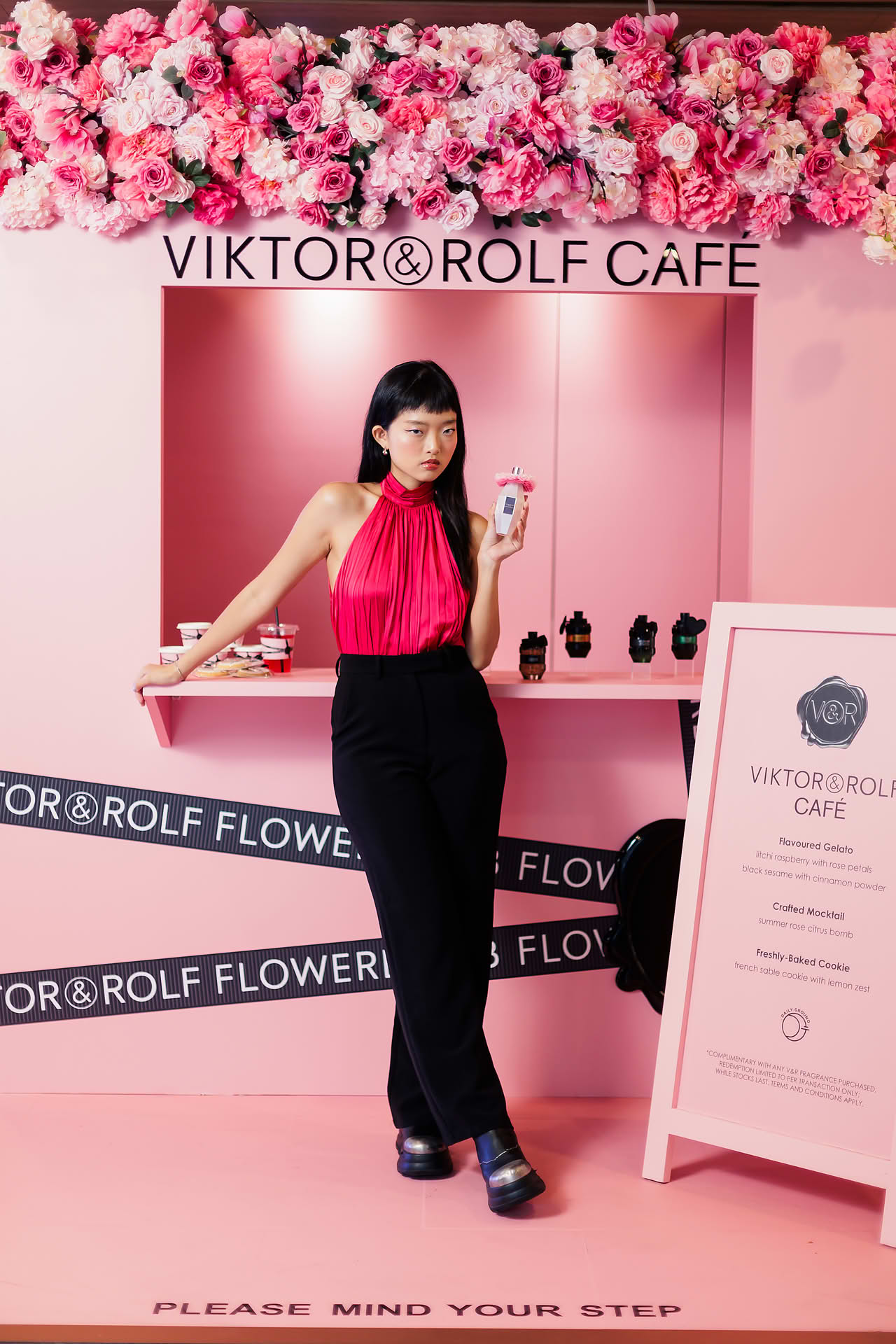 Influencers holding a perfume at Vicktor Rolf Cafe pop-up stall in Paragon