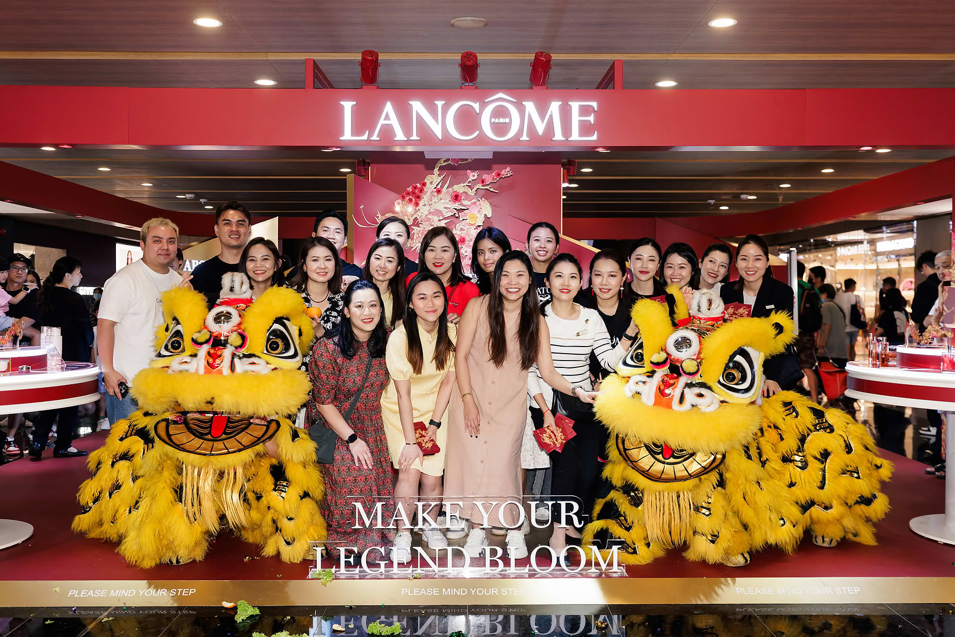 Staff taking group photo with lion at Lancome Chinese New Year lion dance celebration