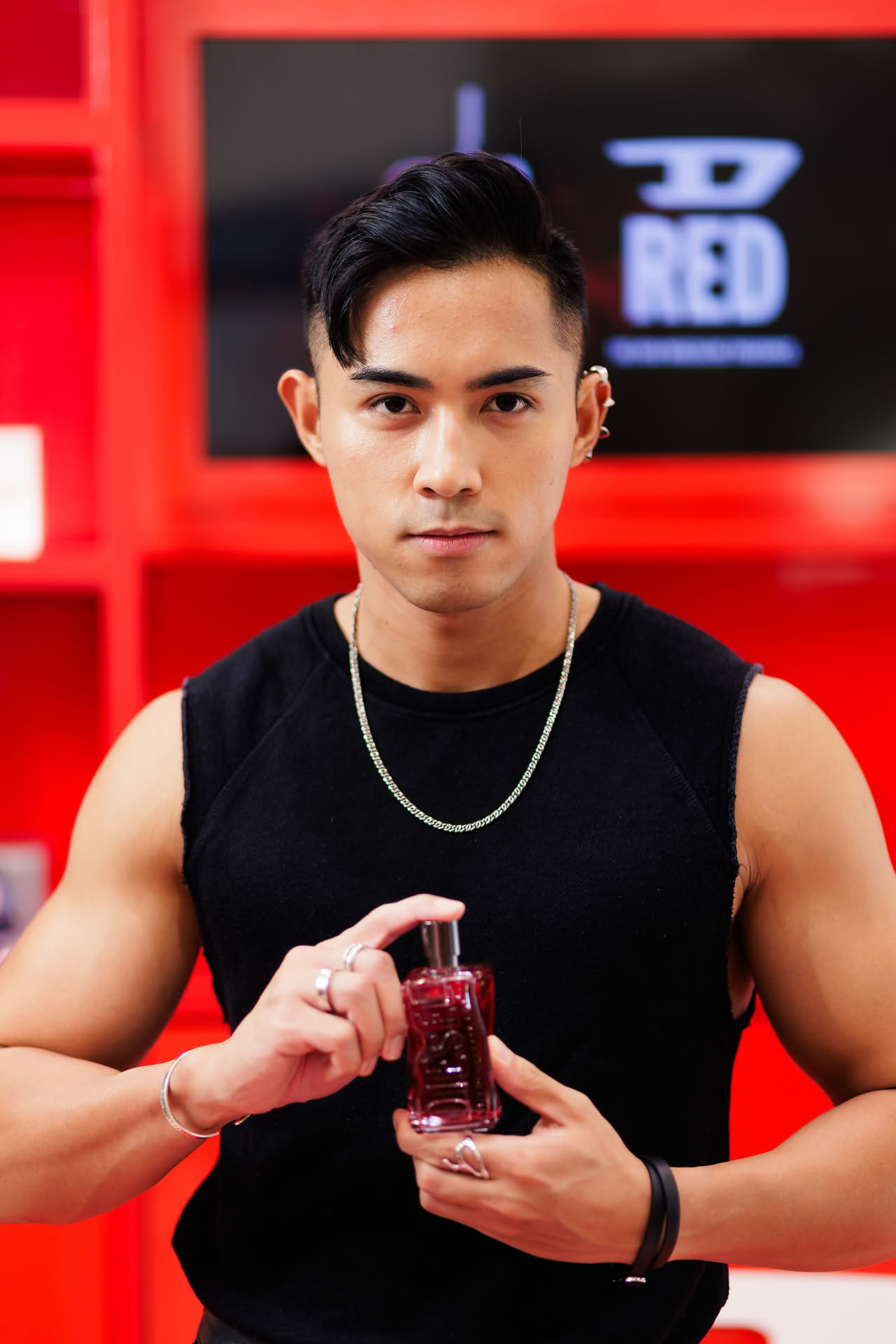 Influencer posing with perfume at Diesel pop-up stall at Ngee Ann City
