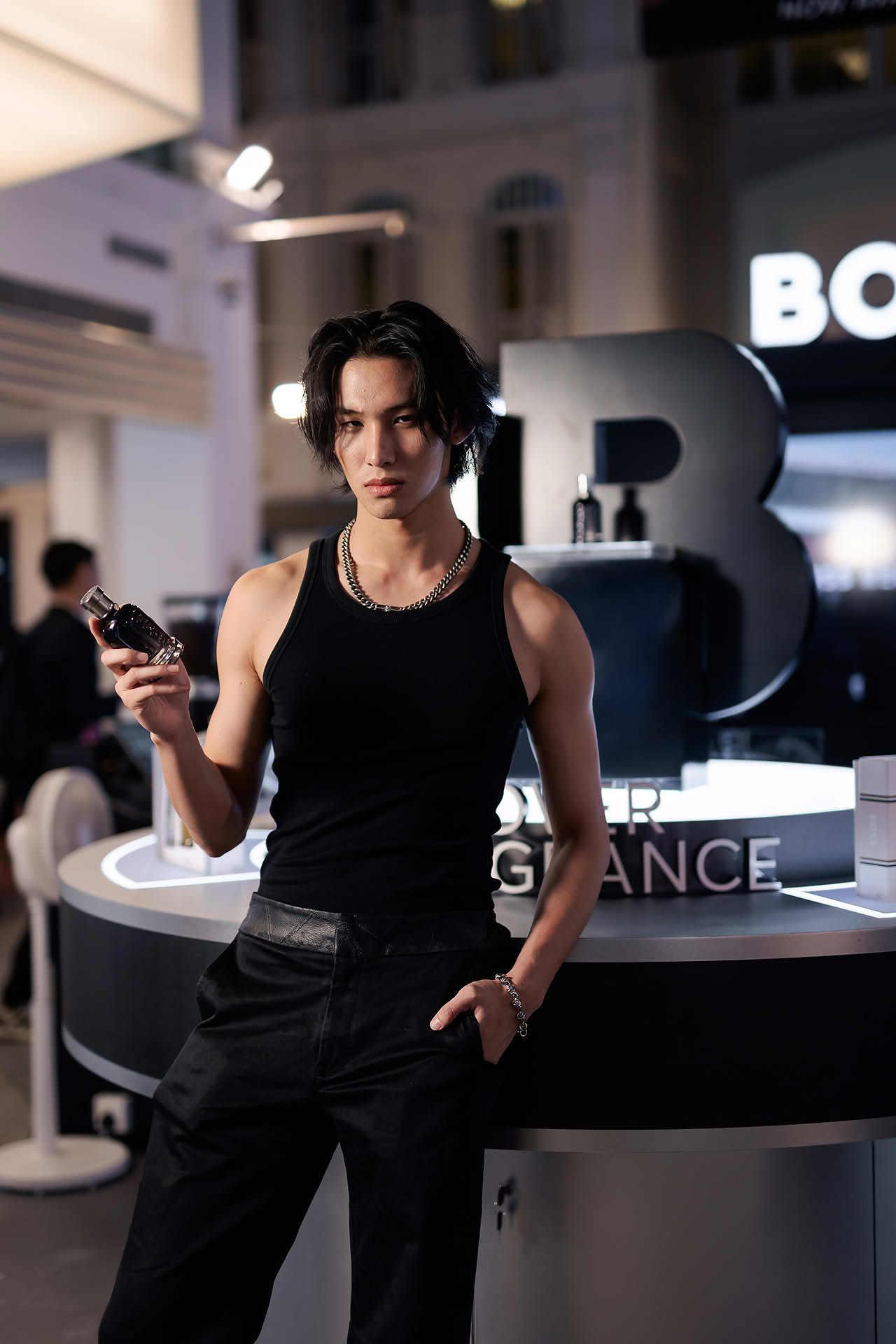 Influencer posing with perfume at BOSS pop-up stall in Bugis Junction