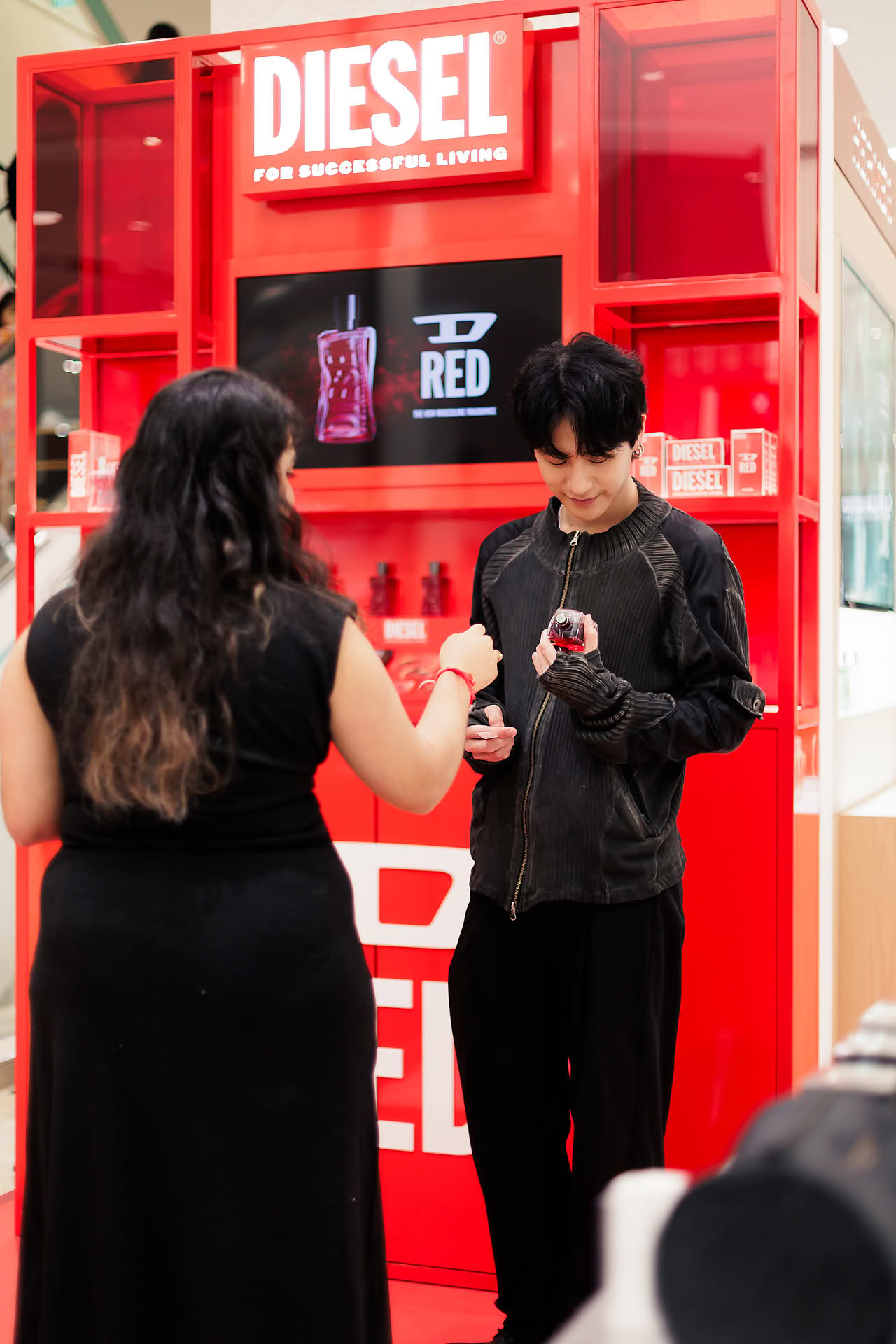 Influencer trying perfume at Diesel pop-up stall at Ngee Ann City