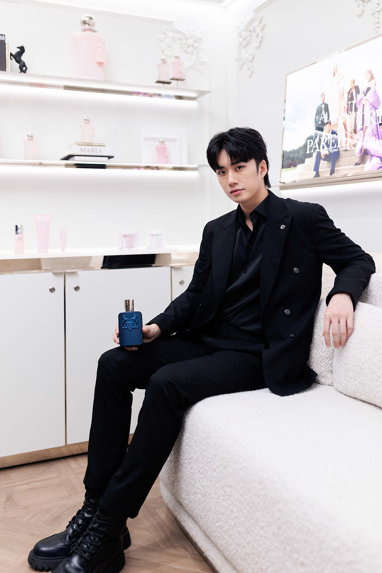 Singer posing with perfume at Parfums de Marly launch event