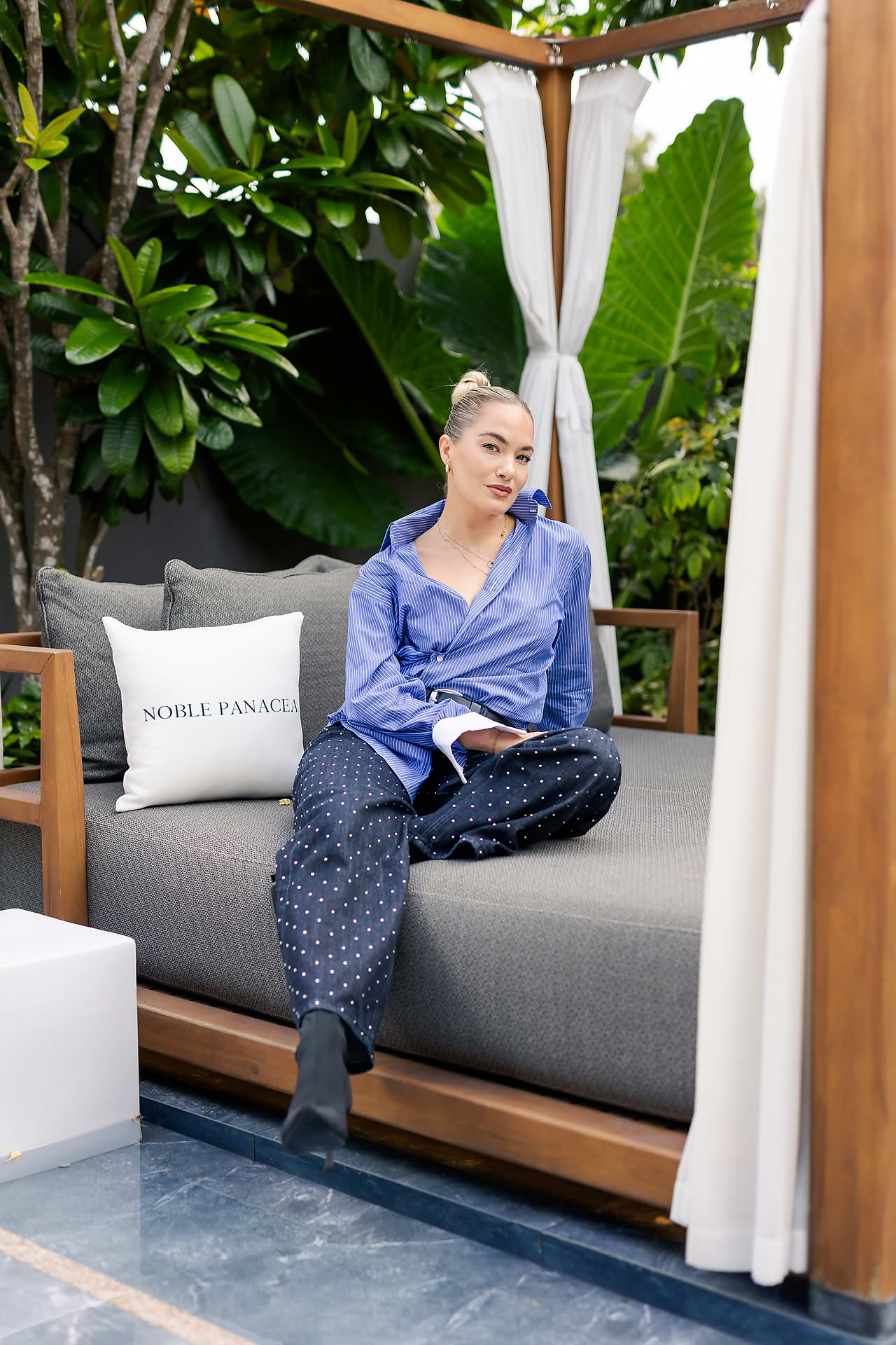 Influencer sitting on a bed at Noble Panacea PR event