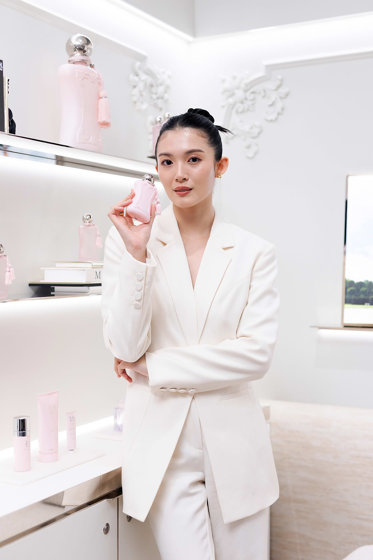 Actress posing with perfume at Parfums de Marly launch event