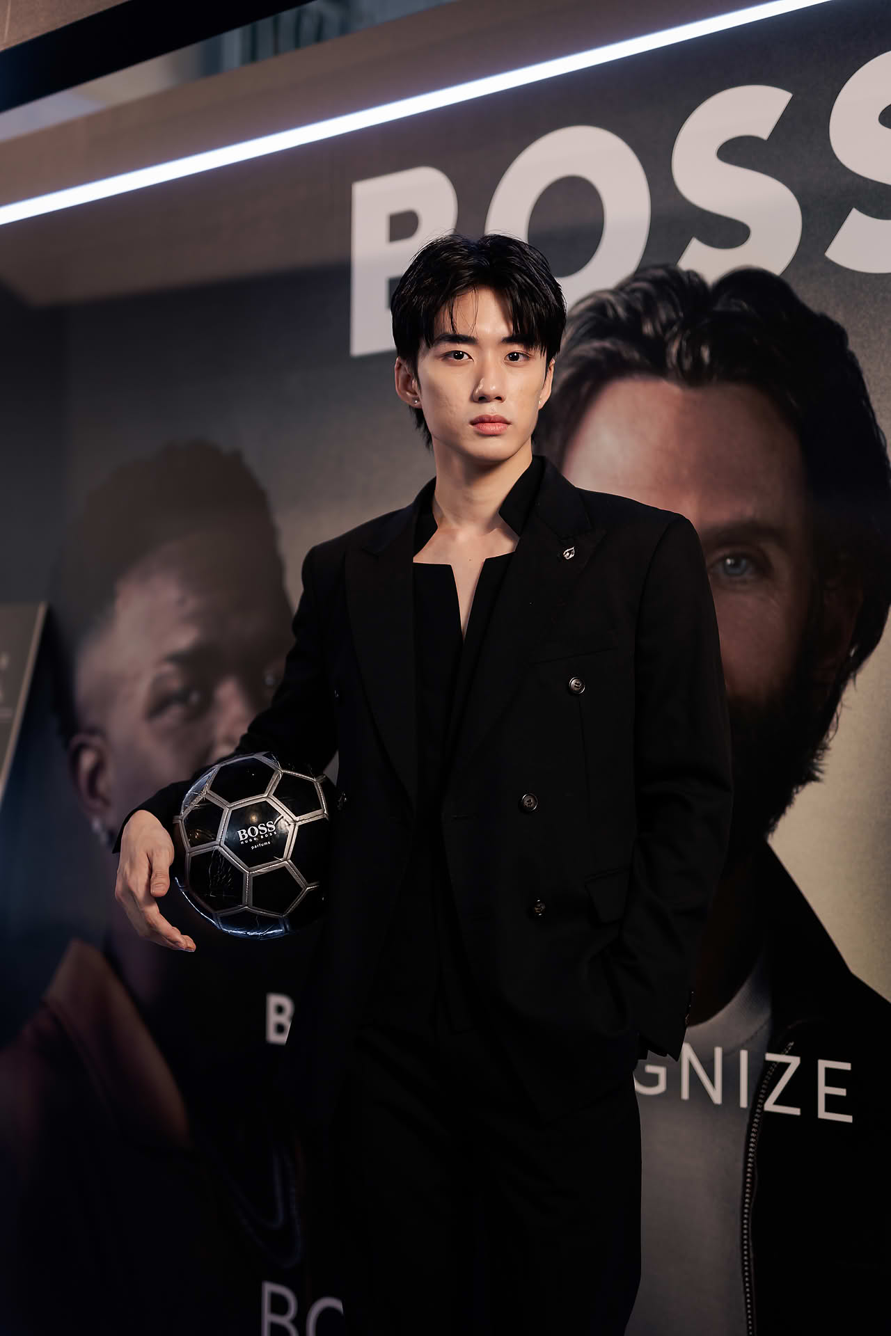 Influencer posing with soccer ball at BOSS pop-up stall in Bugis Junction