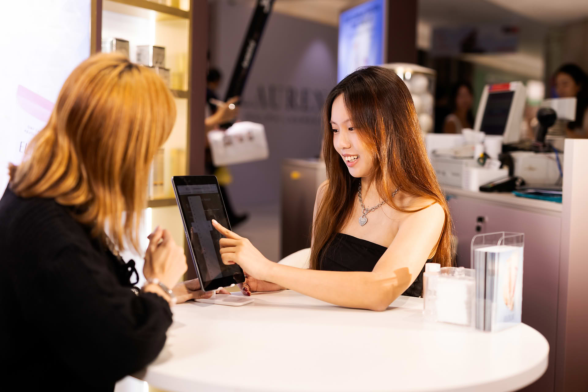 Model taking beauty assement at Exlixir pop-up stall in Ngee Ann City