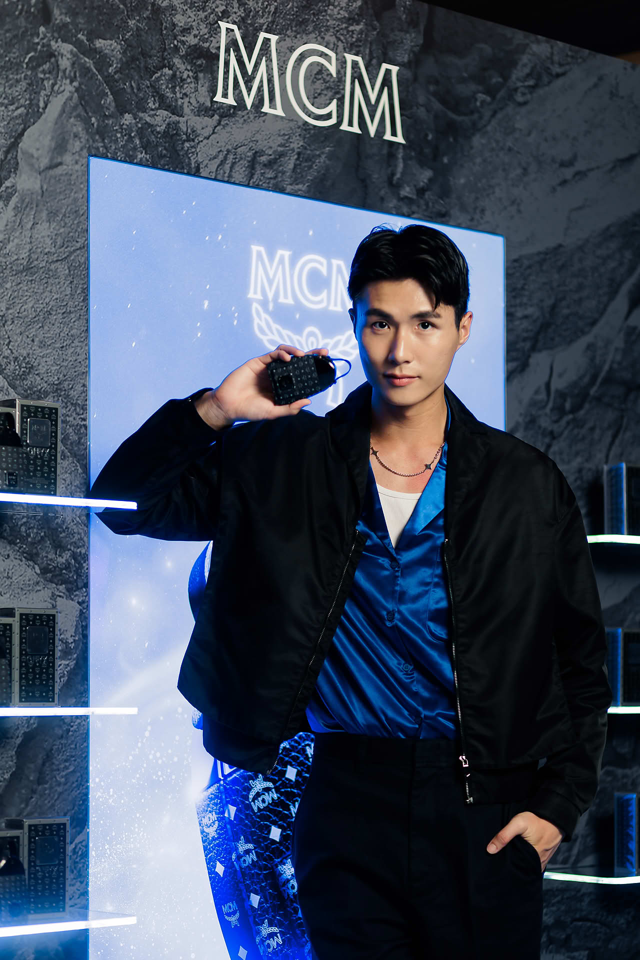 Influencer posing with perfume at MCM pop-up stall at Paragon