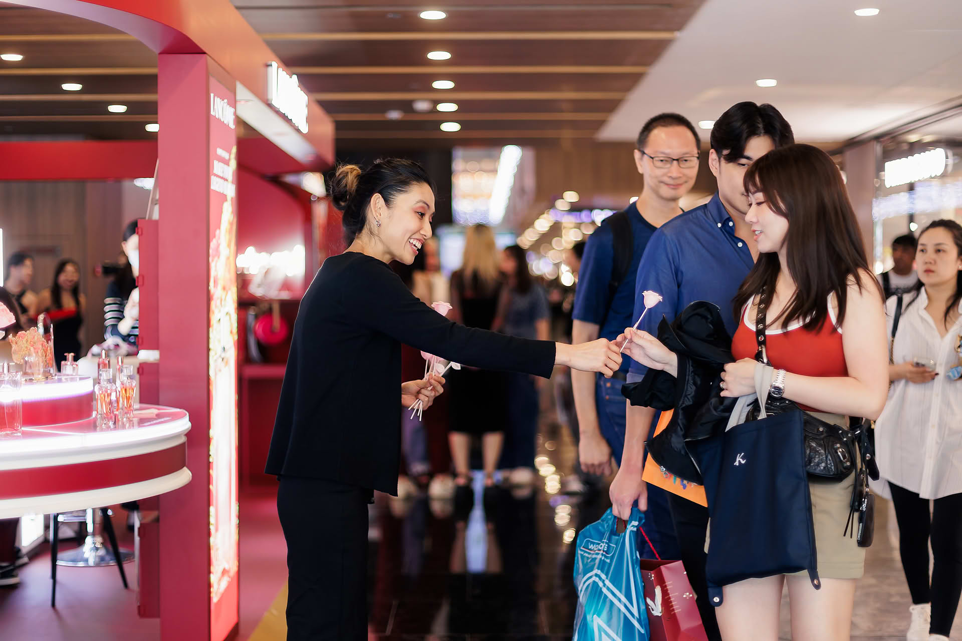 Stafff distributing flowers at Lancome Chinese New Year lion dance celebration