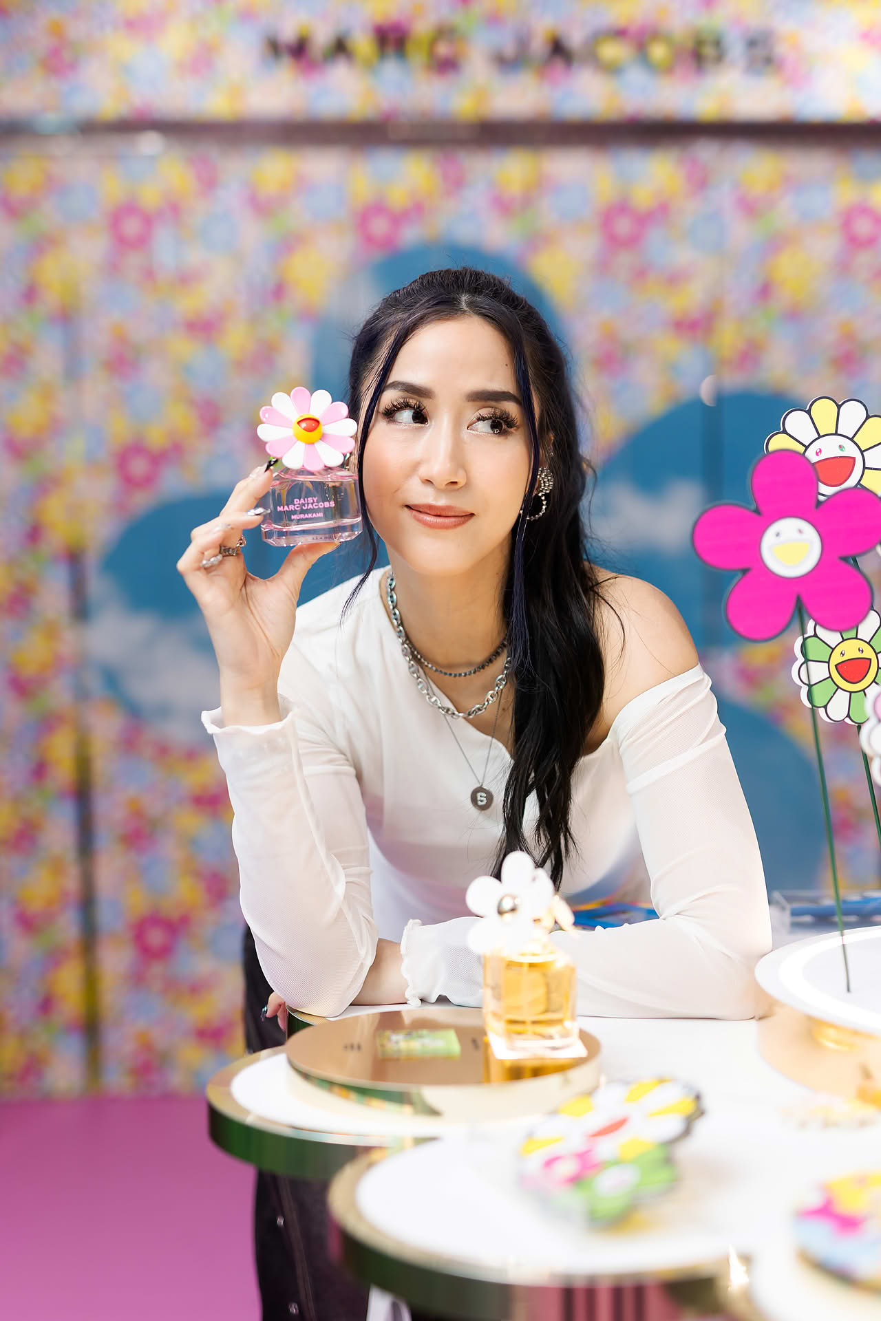 Influencer holding a perfume at Marc Jacobs pop-up stall