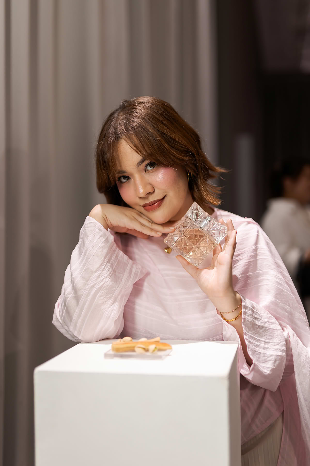 Influencer posing with a perfume at Issey Miyake interactive venue