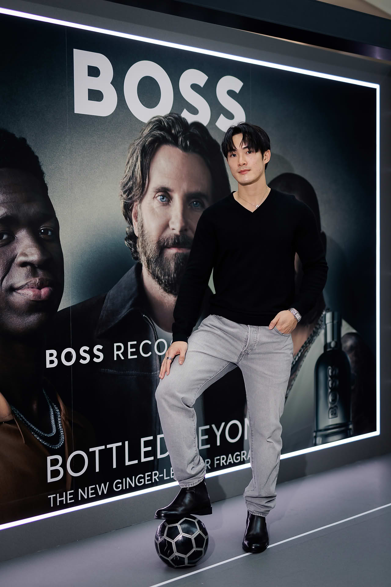 Influencer posing with soccer ball at BOSS pop-up stall in Bugis Junction