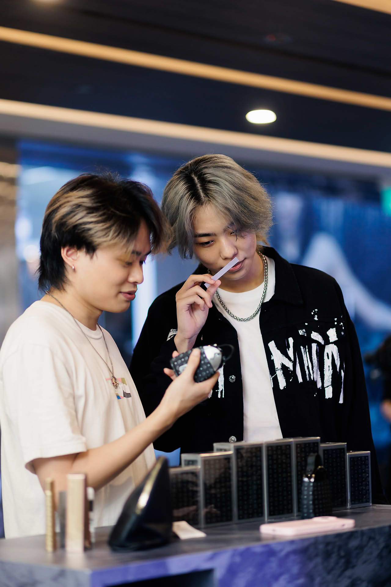 Influencers testing perfume at MCM pop-up stall at Paragon