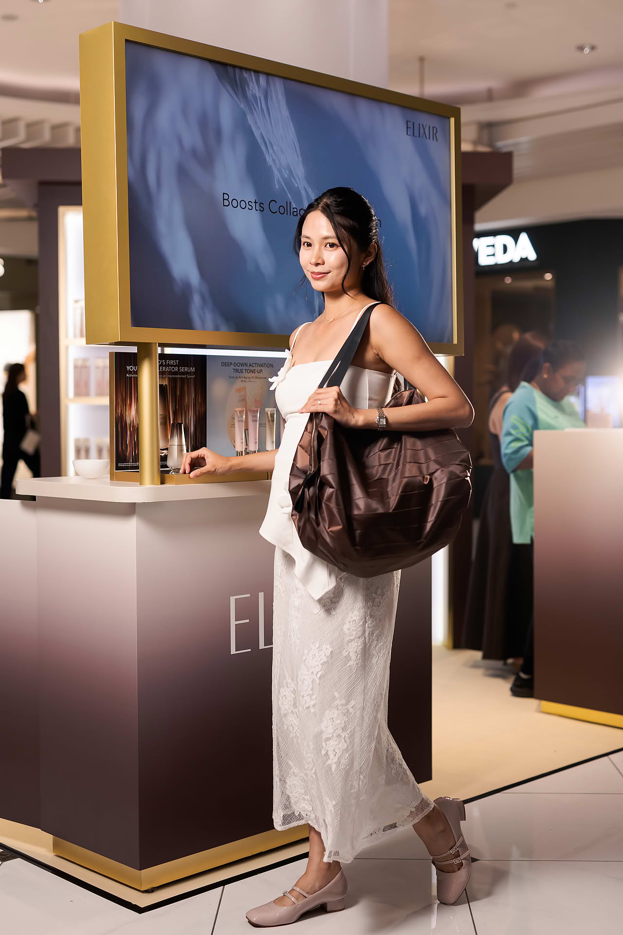 Model holding gift bag for Exlixir pop-up stall in Ngee Ann City