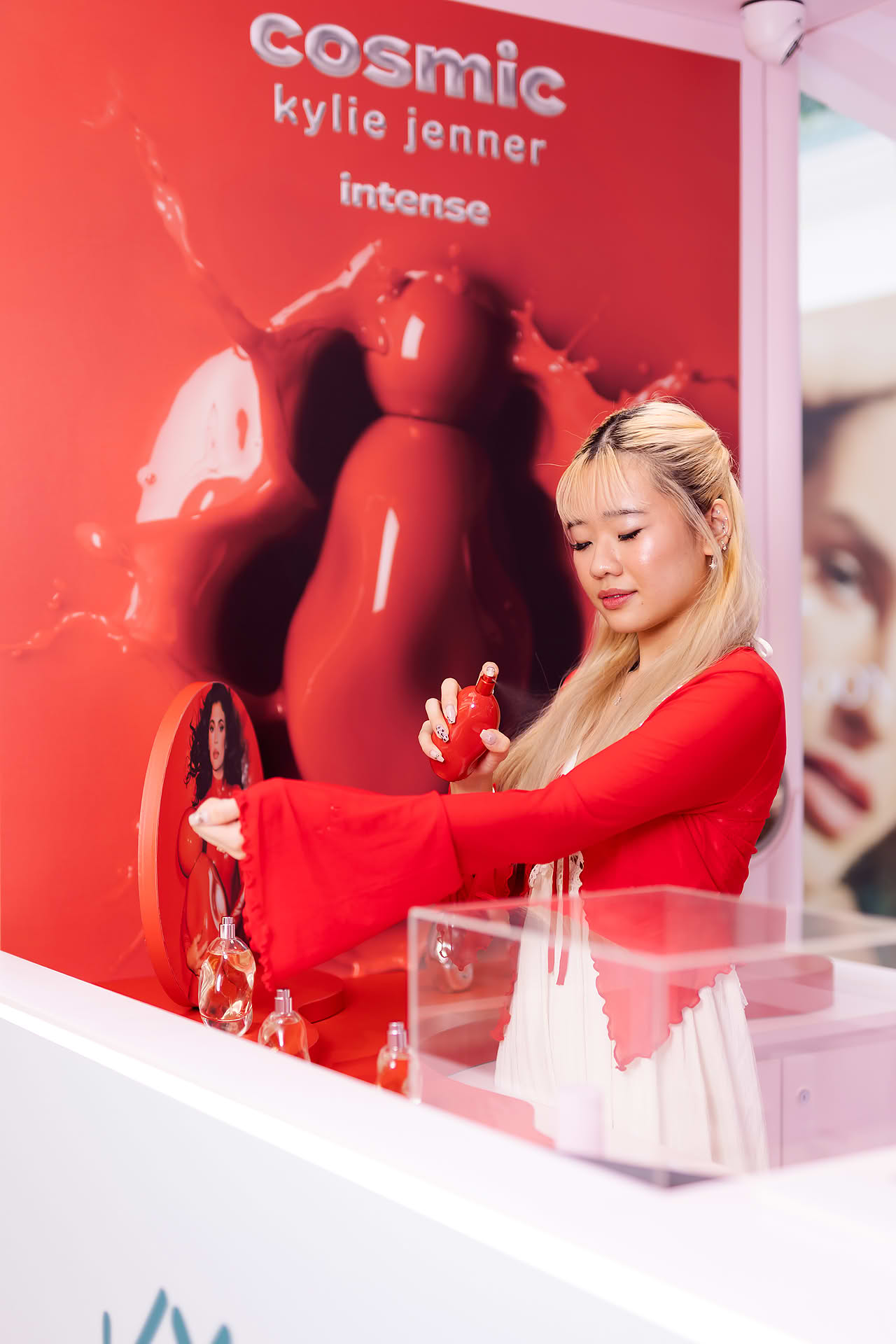 Influencers spraying pefume on herself at Kylie Cosmetics pop-up stall in Bugis Junction