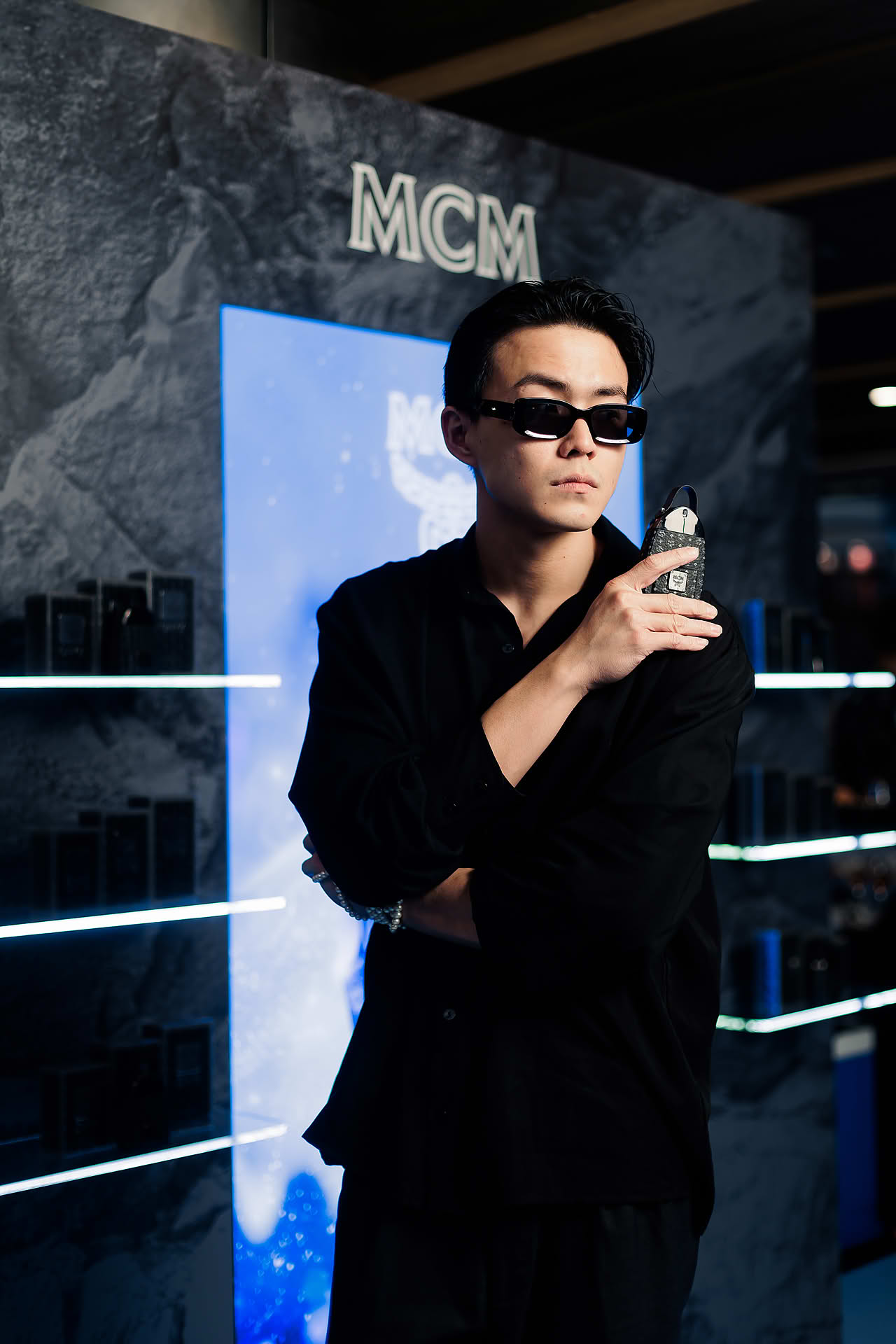 Influencers posing with perfume at MCM pop-up stall at Paragon