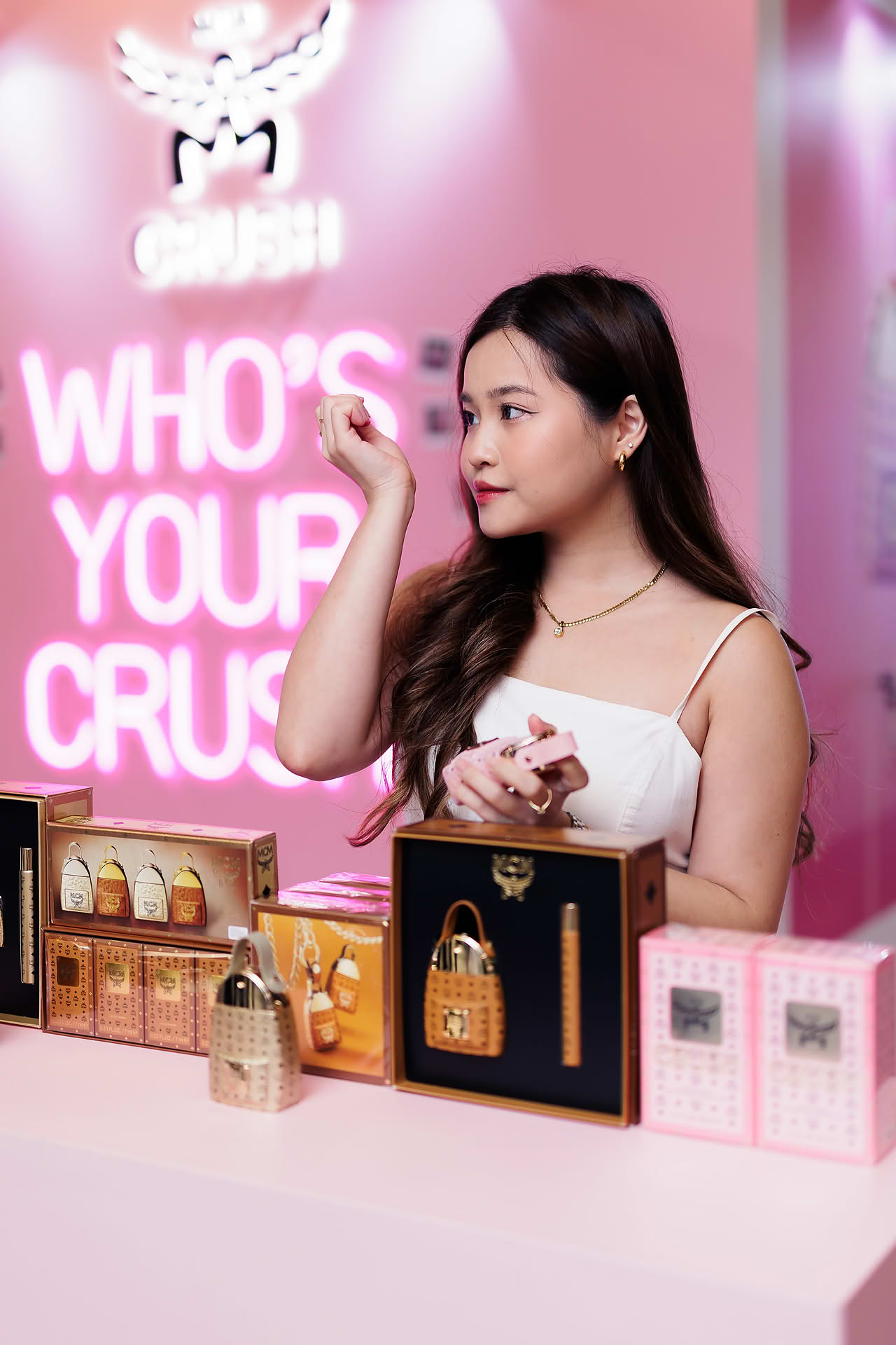 Influencer sniffing MCM Crush perfume at pop-up stall in Ngee Ann City